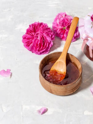 Homemade tea rose petal jam on a light table with copy space.