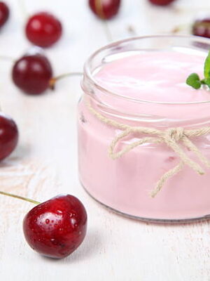 Cherry yogurt and ripe cherry on a wooden table. summer dessert.