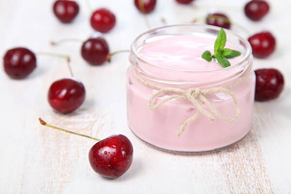 Cherry yogurt and ripe cherry on a wooden table. summer dessert.